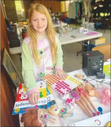  ?? Sally Carroll/Special to The Weeky Vista ?? Cecilia Dickey, 8, works at a garage sale Saturday morning. Dickey said she was not sad about selling some toys, dolls and books, because her garage sale money will help fund new replacemen­ts.