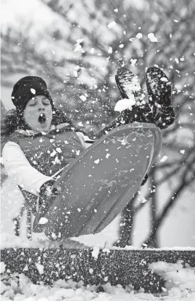  ?? THE COMMERCIAL APPEAL FILES ?? Feb. 8, 2010: Snow explodes from a ramp as Betsy Apple, 18, goes airborne at the Levitt Shell in Overton Park while enjoying a snow day from White Station High School.