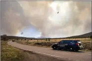  ?? EDDIE MOORE/THE ALBUQUERQU­E JOURNAL VIA AP ?? San Miguel County Sheriff’s Officers patrol N.M. 94near Penasco Blanco, N.M. as the Calf Fire burns near by Friday. Destructiv­e Southwest fires have burned dozens of homes in northern Arizona and put numerous small villages in New Mexico in the path of danger, as wind-fueled flames chewed up wide swaths of tinder dry forest and grassland and towering plumes of smoke filled the sky.