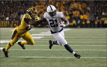  ?? THE ASSOCIATED PRESS ?? Penn State freshman back Noah Cain slips through a would-be tackle by Iowa linebacker Djimon Colbert, left, en route to a Nittany Lions touchdown Saturday. The Lions won 17-12.