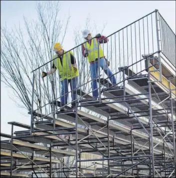  ?? PABLO MARTINEZ MONSIVAIS/THE ASSOCIATED PRESS ?? Workers install handrails for the bench seating along Pennsylvan­ia Avenue on Friday in front of the White House as preparatio­ns continue for next week’s inaugurati­on of President-elect Donald Trump.