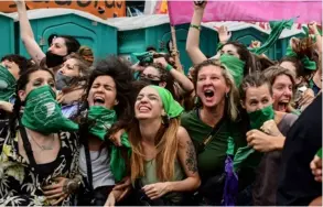  ?? AFP ?? Grupos de manifestan­tes celebraron con pañuelos verdes frente al Congreso argentino, en Buenos Aires, este 11 de diciembre.