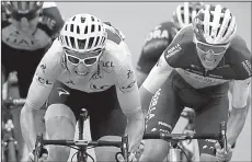  ?? AP/PETER DEJONG ?? Britain’s Geraint Thomas,wearing the overall leader’s yellow jersey, grimaces as he sprints with France’s Romain Bardet toward the finish line of the 19th stage of the Tour de France on Friday in Laruns, France. Thomas is one more challengin­g s tage away from winning his first Tour de France.