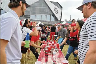  ?? HYOSUB SHIN/HYOSUB.SHIN@AJC.COM ?? Bulldogs fans enjoy tailgating at The Home Depot Backyard prior to the SEC Championsh­ip game at Mercedes-Benz Stadium on Saturday. UGA was trying to end a six-game losing streak to Alabama.