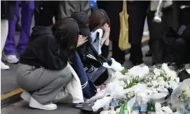  ?? Photograph: Lee Jin-man/AP ?? Women pray for victims of a deadly accident following Saturday night's Halloween festivitie­s on the street near the scene in Seoul.
