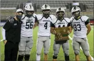  ?? DAVID C. TURBEN — FOR THE NEWS-HERALD ?? Lake Catholic coach Marty Gibbons and team captians Sean Gibbons (56), Joe Malchesky (4), Simon Taraska (44) and Ryan Joy (33) receive their regional championsh­ip trophy after defeating Youngstown Ursuline.