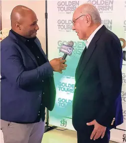  ??  ?? Royal Shop’s Allan Daswani (right), the only living non-inherited duty-free retailer in Jamaica, recognised for 50 years of business in tourism. Here he is being interviewe­d by Business Access TV.