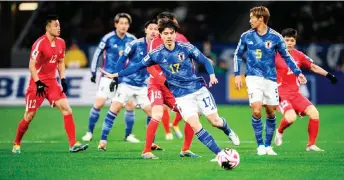  ?? — AFP photo ?? Japan’s Ao Tanaka (centre) controls the ball during their World Cup 2026 qualifier match against North Korea at the National Stadium in Tokyo.