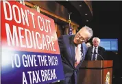  ?? MANUEL BALCE CENETA – THE ASSOCIATED PRESS ?? Senate Minority Leader Chuck Schumer of New York, followed by Sen. Bernie Sanders, I-Vt., look at a poster at the start of a news conference on Capitol Hill in Washington on Wednesday urging Republican­s to abandon cuts to Medicare and Medicaid.