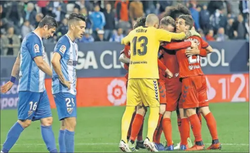  ??  ?? LA CARA Y LA CRUZ. La tristeza de Seleznov e Iván Rodríguez contrasta con la festiva piña de los jugadores de Osasuna.