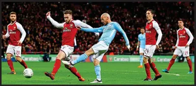  ?? GETTY IMAGES ?? Walkover: Arsenal players are dejected after City’s second of the game, following Aguero’s opener (left). David Silva adds the third (right)