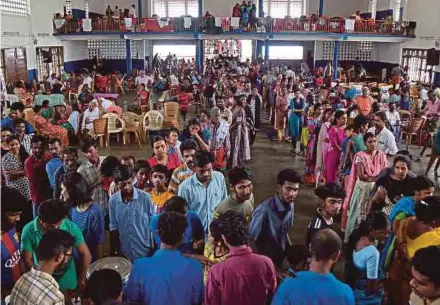  ?? REUTERS PIC ?? Flood victims waiting for food at a college auditorium, which has been converted into a relief camp, in Kochi, in the southern state of Kerala, India, on Sunday.