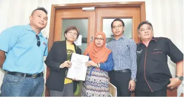  ??  ?? Teo (second left) presents the memorandum to EC Sarawak deputy director Suriani Saruji (third right). Also seen are (from left) PKR Mambong branch chairman Willie Mongin, LK4C co-director Saifulniza­m Sam and DTTG representa­tive Douglas Las.