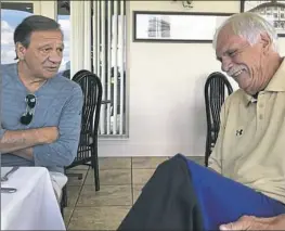  ??  ?? Ringgold football coach Mike Zmijanac, right, a former Aliquippa coach, can't hold back a laugh while speaking with another former Aliquippa coach, Don Yannessa, at a luncheon July 18 at Grand View Golf Course in Braddock.