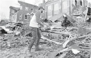  ?? MARK HUMPHREY/AP ?? The Christmas Day bombing in downtown Nashville, Tennessee, was the latest tragedy to befall Music City in 2020. Above, Sumant Joshi helps clean up rubble at a church damaged by storms that spawned deadly tornadoes in March.