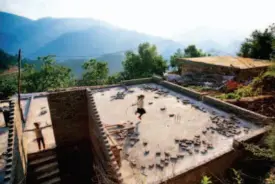  ??  ?? Xiao Rui jumps rope on the unfinished roof of her house. After the catastroph­ic earthquake, the local government funded reconstruc­tion of every dwelling. In hopes of building a better house for the family, her father took work outside the village.