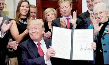  ??  ?? Trump smiles after signing an Executive Order to make it easier for Americans to buy bare-bone health insurance plans and circumvent Obamacare rules at the White House in Washington. — Reuters photo