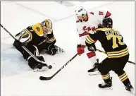  ?? Michael Dwyer / Associated Press ?? Bruins goalie Jeremy Swayman, left, blocks a shot by Hurricanes’ Vincent Trocheck (16) as Bruins’ Connor Clifton defends during the first period Thursday.