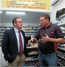  ??  ?? Groom MP Dr John McVeigh (left) speaks with Cambooya Post Office licensee Ash Strugnelli inside the pharmacy.