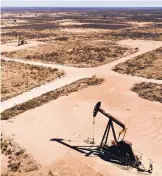  ?? DANIEL ACKER/BLOOMBERG ?? Pumpjacks operate in the Permian Basin in Texas. Exxon Mobil Corp. aims to reduce the cost of pumping oil to about $15 a barrel in the Permian, in West Texas and Eastern New Mexico.