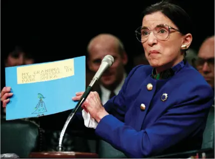  ?? (Gary Hershorn/Reuters) ?? RUTH BADER GINSBURG appears before the Senate Judiciary Committee for her Supreme Court confirmati­on hearing in 1993 – holding a sign made by her grandson.