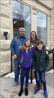  ?? PHOTO COURTESY OF SLEEPY DOG BOOKS ?? Jennifer and Riley Justis, owners of Sleepy Dog Books, and their family outside of what will soon be the Sleepy Dog Books shop in downtown Mt. Pleasant.