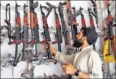  ?? AFP ?? A Pakistani arms seller picks a rifle from a shelf at his shop in Darra Adamkhel.