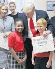  ?? Joe Burbank Associated Press ?? PRESIDENT TRUMP thanks fourth-graders for greeting cards they presented at his visit last month to St. Andrew Catholic School in Orlando, Fla.