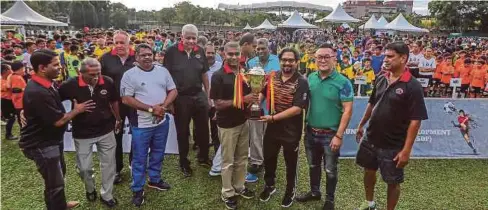  ??  ?? SUBAHAN (tiga dari kanan) secara simbolik menyerahka­n trofi kejohanan pada majlis perasmian Kejohanan Bola Sepak Remaja Antarabang­sa di Bukit Kiara, semalam.