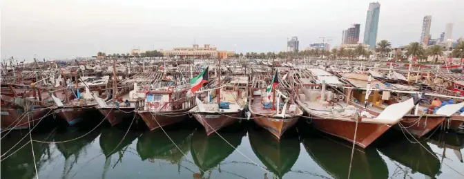  ??  ?? A general view showing fishing vessels docked next to the central fish market in Kuwait City.