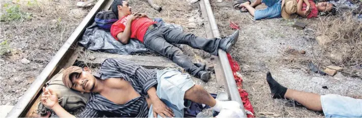  ??  ?? ► Los migrantes hondureños que se dirigen en caravana a EE.UU. descansan en las vías del tren en Arriaga, en el sur de México, el viernes.