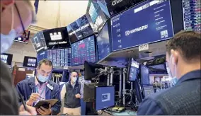  ?? Nicole Pereira / NYSE via Associated Press ?? Traders work on the floor on Friday in New York. The Dow Jones Industrial Average, which set an all-time high Thursday, was up.