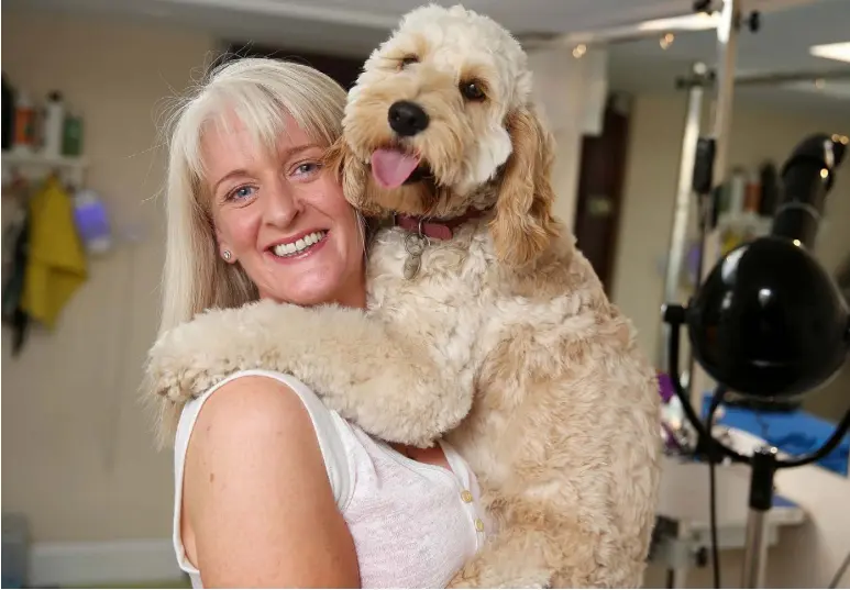  ??  ?? Former PR executive Maria Murphy, who wanted a change of career and now grooms four dogs a day, at her Paws Parlour in Blackrock with Ella. Photo: Gerry Mooney