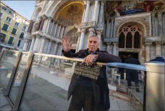  ?? (AP/Domenico Stinellis) ?? Procurator of St. Mark’s Basilica Mario Piana leans on a glass tide barrier Dec. 7 during an interview with The Associated Press in St. Mark’s Square in Venice, Italy.