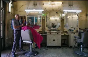  ?? The Associated Press ?? OLD DILEMMA: An Israeli Arab man gets his haircut at a barbershop Friday in Nazareth, northern Israel. Electoral gains made by Arab parties in Israel, and their decision to endorse one of the two deadlocked candidates for prime minister, could give them new influence in parliament. But they also face a dilemma dating back to Israel’s founding: How to participat­e in a system that they say relegates them to second-class citizens and oppresses their Palestinia­n brethren in Gaza and the occupied West Bank.