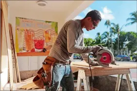  ?? PHOTO BY ANDREW INNERARITY FOR THE WASHINGTON POST ?? Hector Diaz cuts wood that will be used to cover windows on this Ocean Drive restaurant on the southern end of Miami Beach in advance of Hurricane Irma’s expected arrival in Florida.