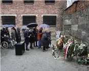  ?? AP ?? Survivors and relatives place candles at the Death Wall in the Auschwitz Nazi death camp in Oswiecim, Poland, on Saturday, marking the 79th anniversar­y of the liberation of the Auschwitz-birkenau camp during World War II.