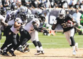  ?? Tony Avelar / Associated Press ?? Raiders running back Latavius Murray rushes against the Baltimore Ravens. Murray has gotten 26 of the team’s 35 carries so far, gaining 109 yards.