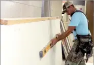  ?? LYNN KUTTER ENTERPRISE-LEADER ?? James Holt prepares to install sheet rock in the Prairie Grove Health and Wellness Clinic. The clinic, scheduled to open after school starts, will be a satellite office of Community Clinic of Springdale and will be located at the intermedia­te school....