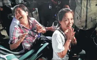  ?? LILLIAN SUWANRUMPH­A / AFP ?? Family members — camping out near Tham Luang cave in Thailand’s Khun Nam Nang Non Forest Park — celebrate upon hearing the news that all members of their children’s soccer team and its coach were found alive late on Monday.