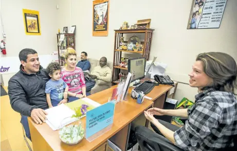  ?? BOB TYMCZYSZYN/POSTMEDIA NETWORK ?? Travis Cotton at Niagara Folk Arts helps some visitors to the multicultu­ral centre in St. Catharines.