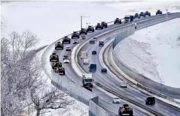  ?? —
AP ?? A convoy of Russian armoured vehicles moves along a highway in Crimea. They are participat­ing in military drills that are alleged to be aimed at unsettling Ukraine.