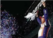  ?? Jared C. Tilton / Getty Images ?? Denny Hamlin whoops it up in Victory Lane after surviving five wrecks in the last 20 laps of regulation.