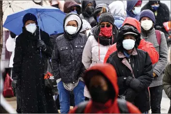  ?? MATT ROURKE — THE ASSOCIATED PRESS FILE ?? U.S. health authoritie­s say after being vaccinated, people should follow the same rules as everybody else about wearing a mask, keeping a 6-foot distance and avoiding crowds even after they have gotten their second vaccine dose.