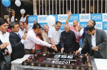  ?? (Shailesh Andrade/Reuters) ?? EMPLOYEES OF the Bombay Stock Exchange (BSE) cut a cake outside the building to celebrate the Sensex index rising to over 30,000 in Mumbai last month. The stock-market rally is partly the result of a drive by Prime Minister Narendra Modi’s government...