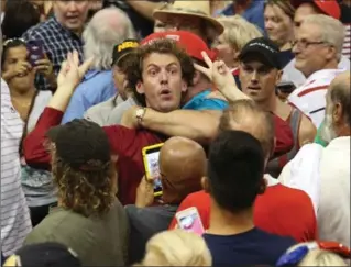  ?? RED HUBER, TNS ?? A protester is detained by Donald Trump supporters during a rally by the Republican Presidenti­al candidate at Ocean Center Wednesday, in Daytona Beach, Fla.