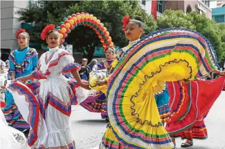  ?? Tim Warner ?? Members of a folklorico dance group perform Saturday during the Cinco de Mayo Parade in downtown Houston. In Mexico, the dances and costumes vary from region to region.