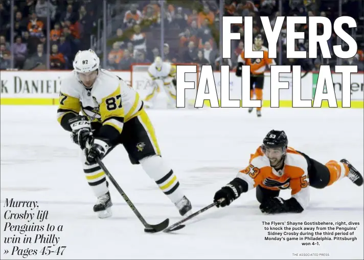  ?? THE ASSOCIATED PRESS ?? The Flyers’ Shayne Gostisbehe­re, right, dives to knock the puck away from the Penguins’ Sidney Crosby during the third period of Monday’s game in Philadelph­ia. Pittsburgh won 4-1.