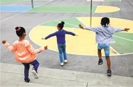  ?? Photos by Jessica Christian / The Chronicle ?? Firstgrade students put their arms out to ensure distancing during Freedom School, a summer program in Marin City.