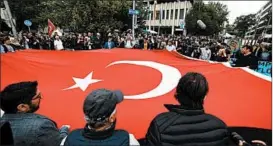  ?? ANDREAS GEBERT/GETTY ?? Members of the Turkish community hold a flag in a show of unity outside a Munich court.